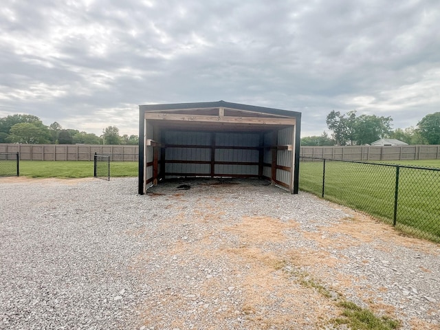 garage with a detached carport and fence