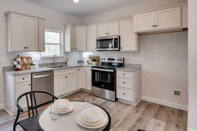 kitchen featuring a sink, appliances with stainless steel finishes, and light wood-style flooring