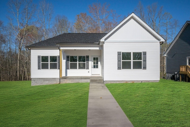 view of front facade with a shingled roof and a front lawn