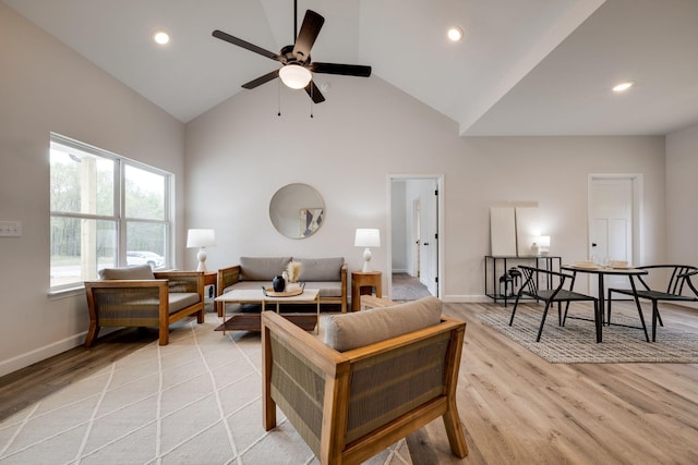 living area with baseboards, high vaulted ceiling, recessed lighting, a ceiling fan, and light wood finished floors