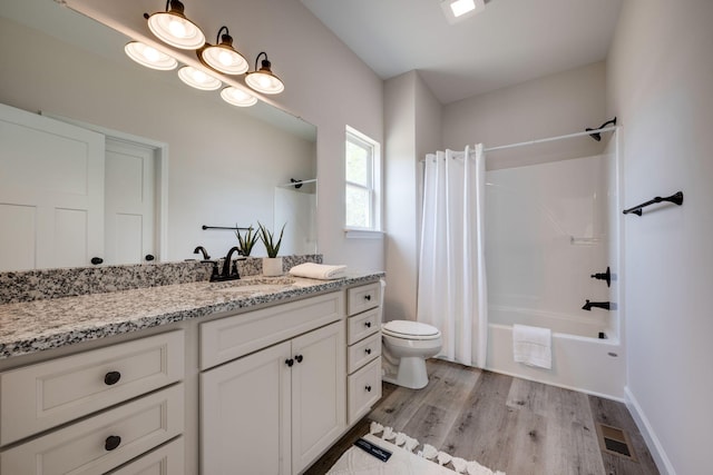 bathroom featuring visible vents, shower / bath combo, wood finished floors, vanity, and toilet