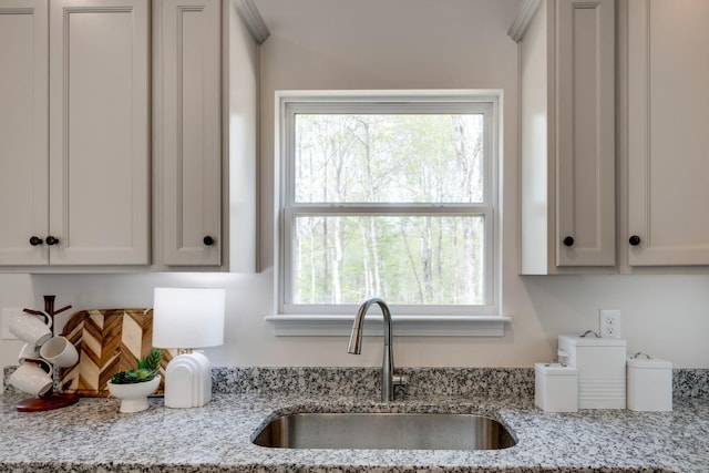 kitchen with a sink and light stone countertops
