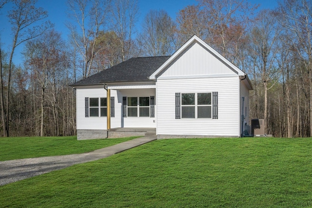 view of front of home with a shingled roof and a front yard