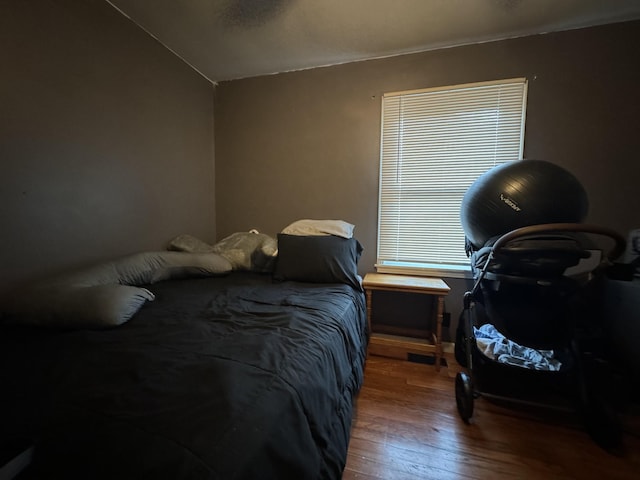 bedroom with hardwood / wood-style flooring and lofted ceiling