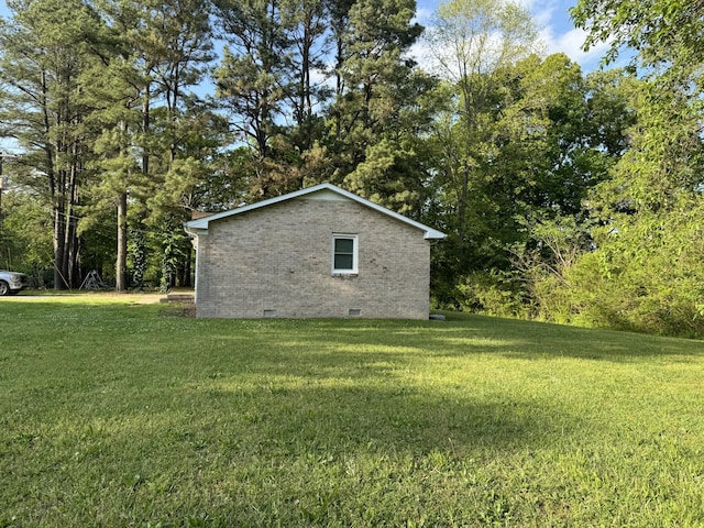 view of side of property featuring brick siding, a yard, and crawl space