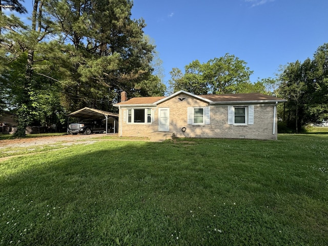 view of front facade with brick siding, a detached carport, a front yard, and a chimney
