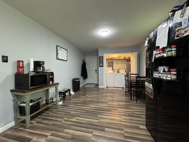interior space featuring baseboards, washer and clothes dryer, and wood finished floors