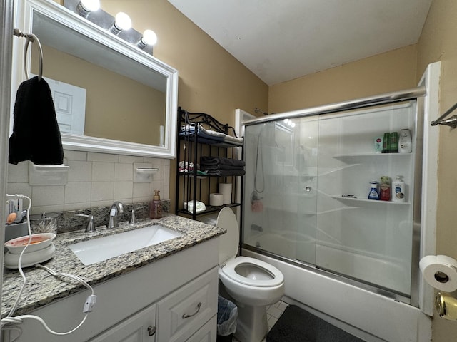 full bath with shower / bath combination with glass door, vanity, toilet, tile patterned floors, and decorative backsplash