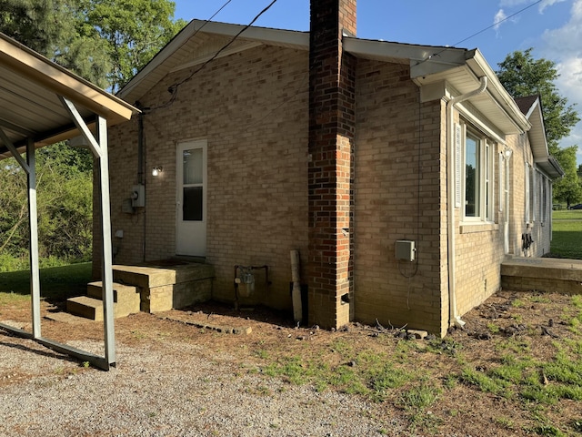 view of property exterior featuring brick siding and a chimney