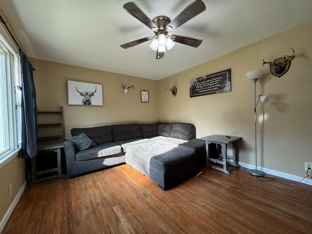 living room featuring baseboards, a ceiling fan, and wood finished floors