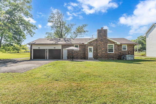 4043 Marydale Dr, Nashville, TN 37207 - view of front of house with a chimney, a front yard, cooling unit, aphalt driveway, and an attached garage