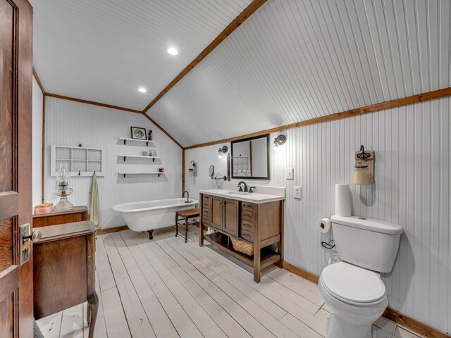 609 W Main St, Waverly, TN 37185 - full bathroom featuring vanity, toilet, baseboards, vaulted ceiling, and a soaking tub