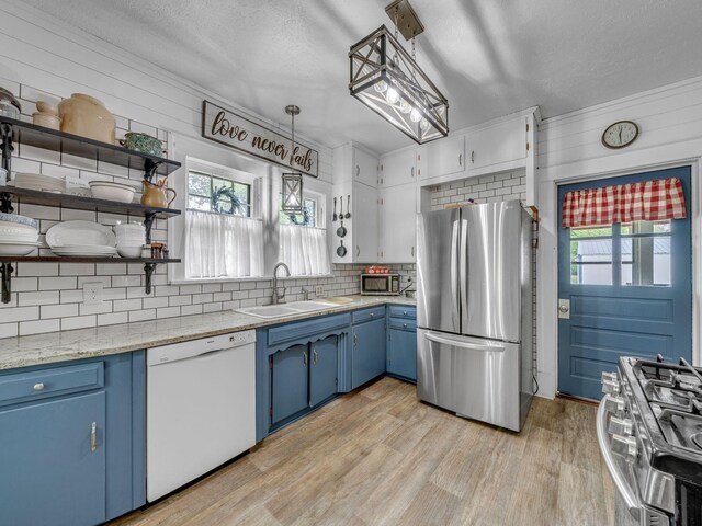 609 W Main St, Waverly, TN 37185 - kitchen featuring blue cabinetry, tasteful backsplash, open shelves, a sink, and stainless steel appliances