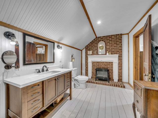 609 W Main St, Waverly, TN 37185 - bathroom with a wood stove, hardwood / wood-style flooring, vanity, toilet, and lofted ceiling