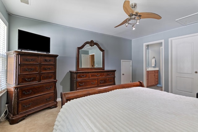 bedroom with attic access, connected bathroom, ceiling fan, and light carpet