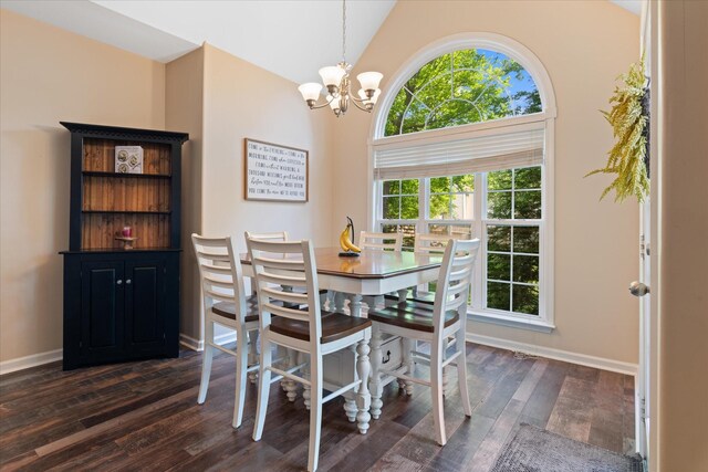 dining room featuring baseboards, dark wood-style flooring, a towering ceiling, and a notable chandelier