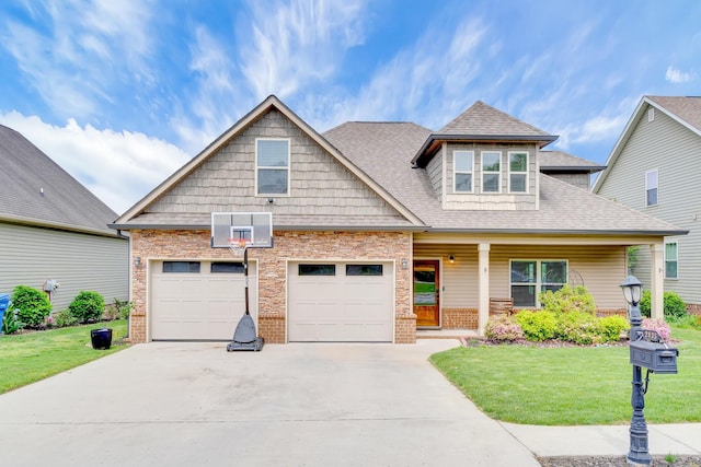 craftsman inspired home featuring a garage, concrete driveway, a front lawn, and brick siding