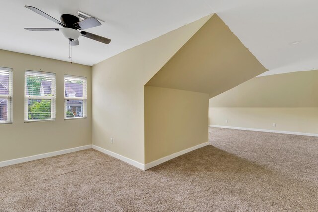 additional living space featuring baseboards, light carpet, and ceiling fan