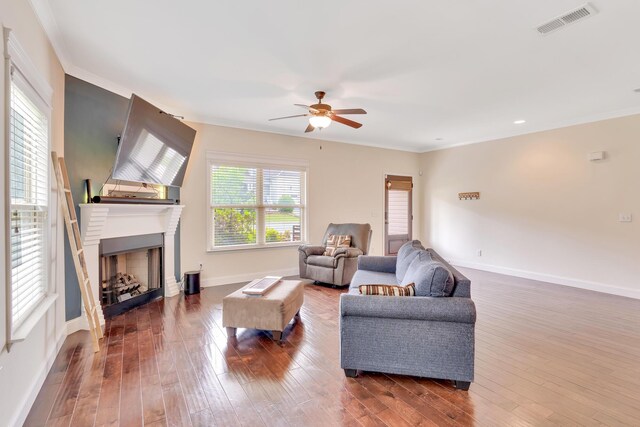 living room with visible vents, a ceiling fan, baseboards, and wood finished floors