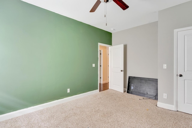 unfurnished bedroom with carpet floors, baseboards, and a ceiling fan