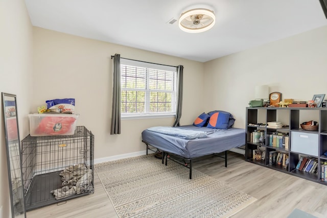 bedroom with baseboards and wood finished floors