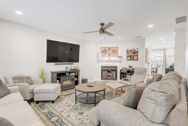 living room featuring a fireplace, a ceiling fan, recessed lighting, wood finished floors, and visible vents