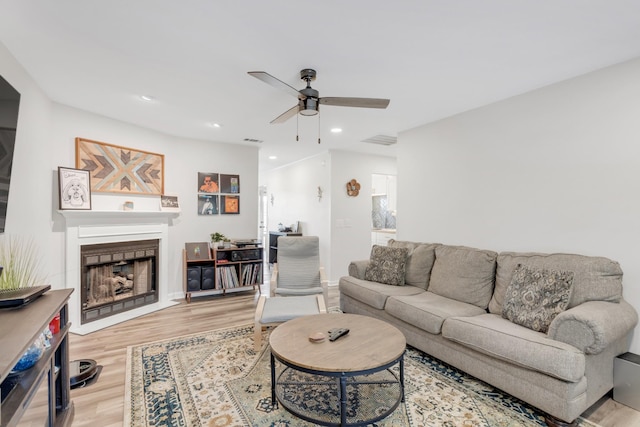 living room featuring wood finished floors, a fireplace, baseboards, recessed lighting, and a ceiling fan