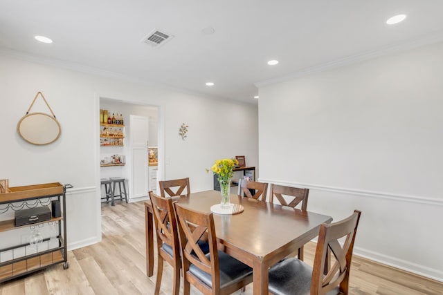 dining area featuring crown molding, visible vents, and light wood-type flooring