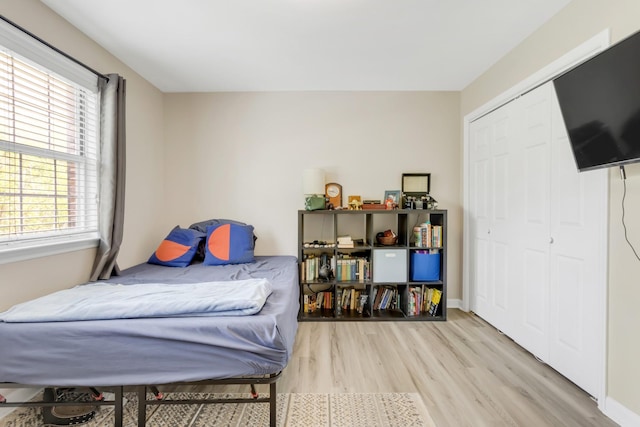 bedroom with a closet, baseboards, and wood finished floors