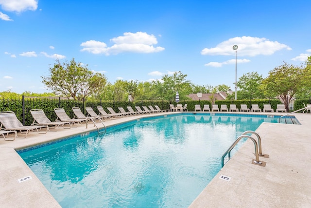pool featuring fence and a patio