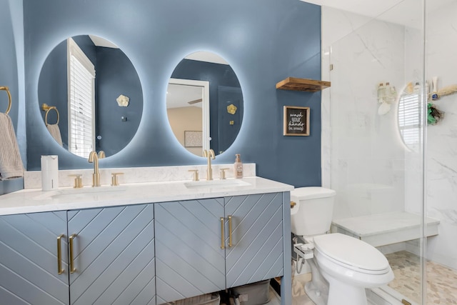 full bathroom featuring double vanity, a sink, toilet, and a shower stall
