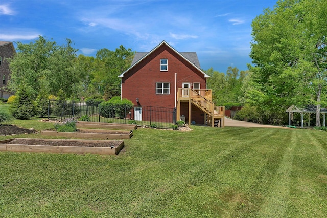 1012 Carrs Creek Blvd, Greenbrier, TN 37073 - rear view of house with stairway, a lawn, fence, and a vegetable garden