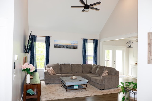 living area with high vaulted ceiling, ceiling fan, and wood finished floors