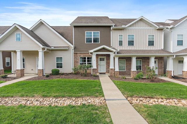 4325 Ashland City Hwy Unit 8, Nashville, TN 37218 - view of front of home featuring covered porch, brick siding, board and batten siding, and a front lawn