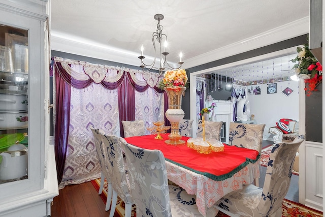 dining space featuring ornamental molding, wood finished floors, and a chandelier