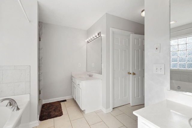 bathroom with vanity, baseboards, tile patterned floors, and a bath