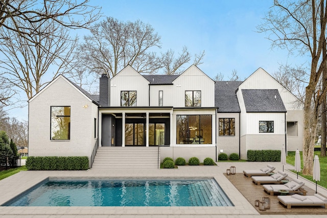 6120 Bresslyn Rd, Nashville, TN 37205 - rear view of property with a sunroom, an outdoor pool, a shingled roof, and a chimney