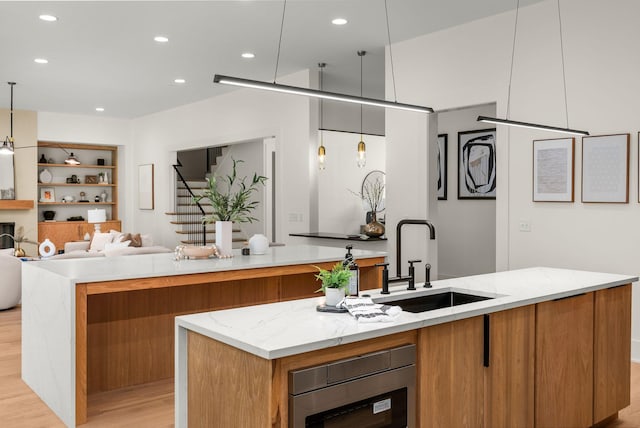 6120 Bresslyn Rd, Nashville, TN 37205 - kitchen featuring a large island, light wood-style floors, modern cabinets, brown cabinets, and open floor plan
