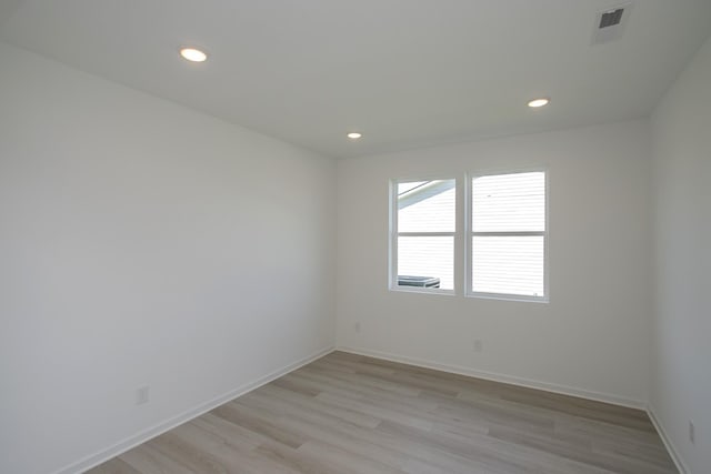 unfurnished room featuring light wood-style floors, baseboards, recessed lighting, and visible vents