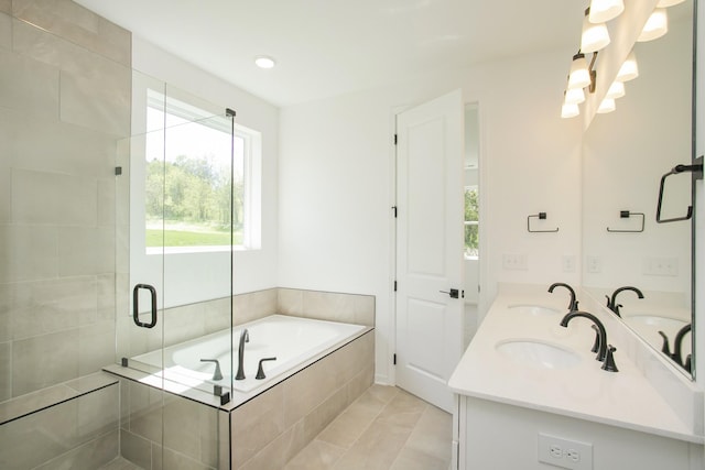 bathroom featuring double vanity, a bath, tile patterned floors, a sink, and a stall shower