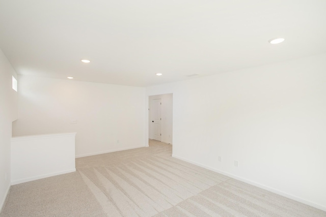 unfurnished room with recessed lighting, baseboards, and light carpet