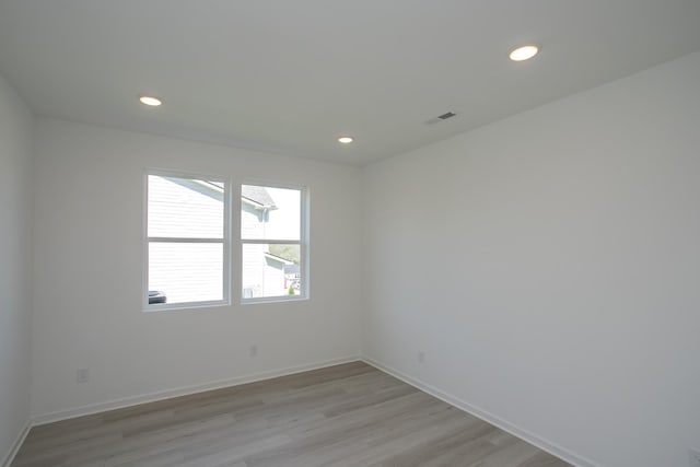 spare room with recessed lighting, light wood-style flooring, baseboards, and visible vents
