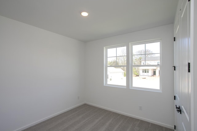 carpeted empty room featuring baseboards and recessed lighting