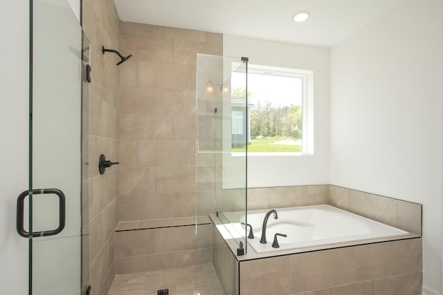 bathroom featuring a shower stall and a bath