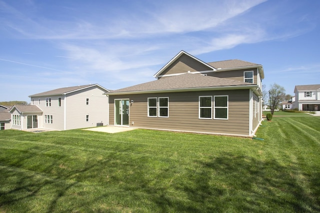 back of house with a lawn and a patio