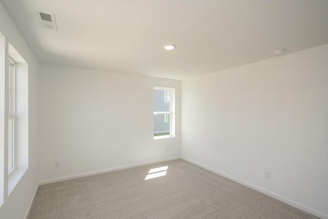 empty room featuring baseboards, light carpet, recessed lighting, and visible vents