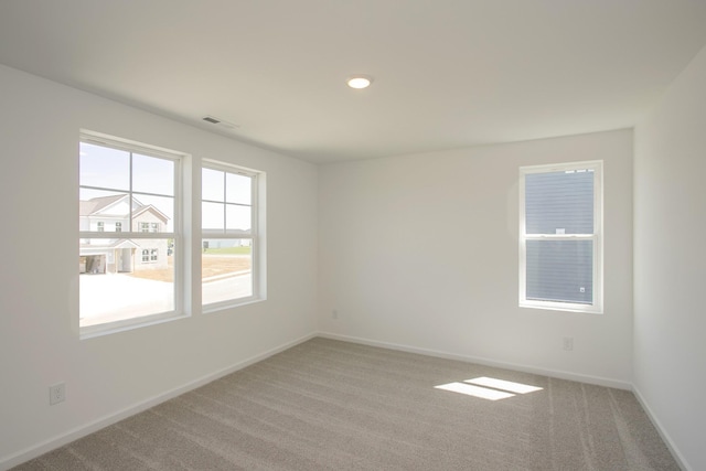 unfurnished room with carpet flooring, baseboards, and visible vents