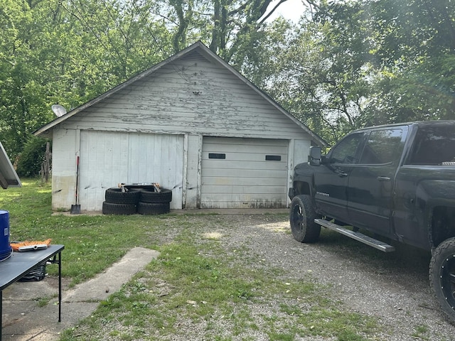 detached garage featuring dirt driveway