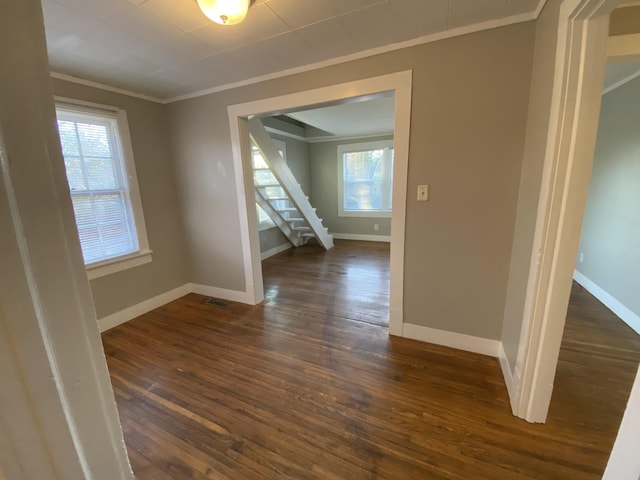 unfurnished room featuring baseboards, ornamental molding, dark wood-style flooring, and stairs
