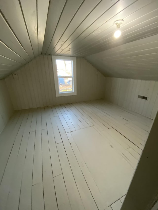additional living space featuring vaulted ceiling and hardwood / wood-style flooring